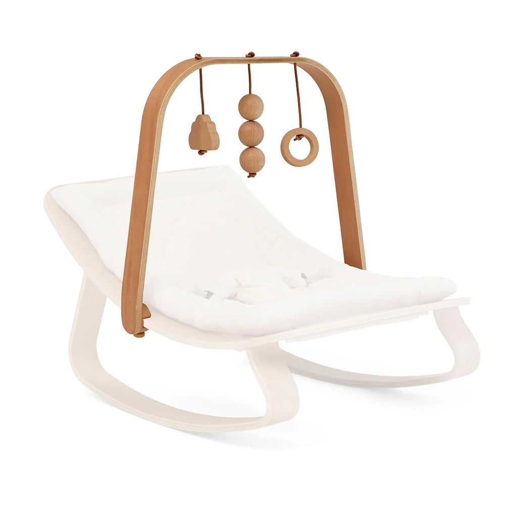 Charlie Crane LEVO activity arch in beech wood with three wooden toys on a LEVO baby rocker