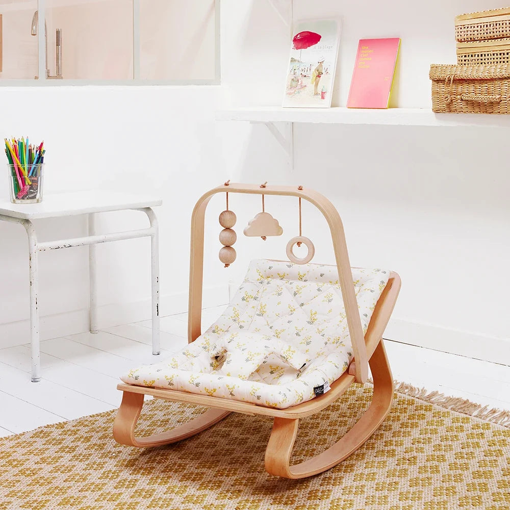 Charlie Crane LEVO baby rocker with beech wood activity arch in a nursery