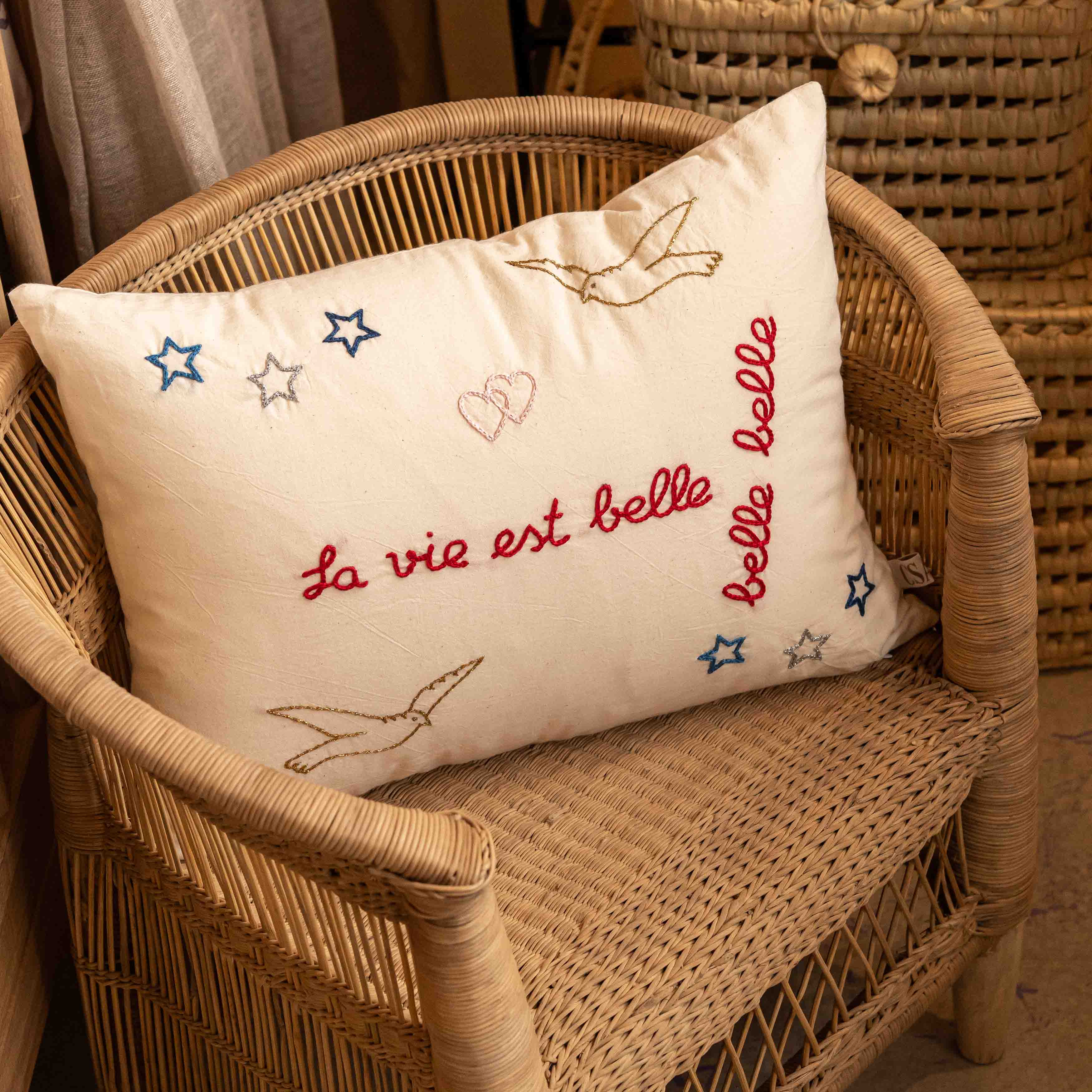 Decorative pillow with embroidered text and stars