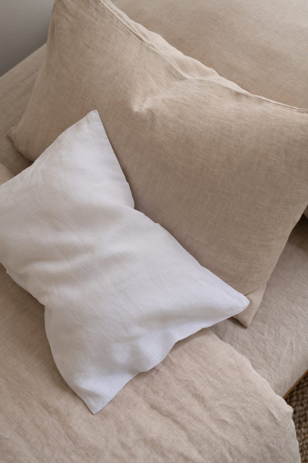 Hazel & George linen pillows in Blanc and Naturel styled together on a bed