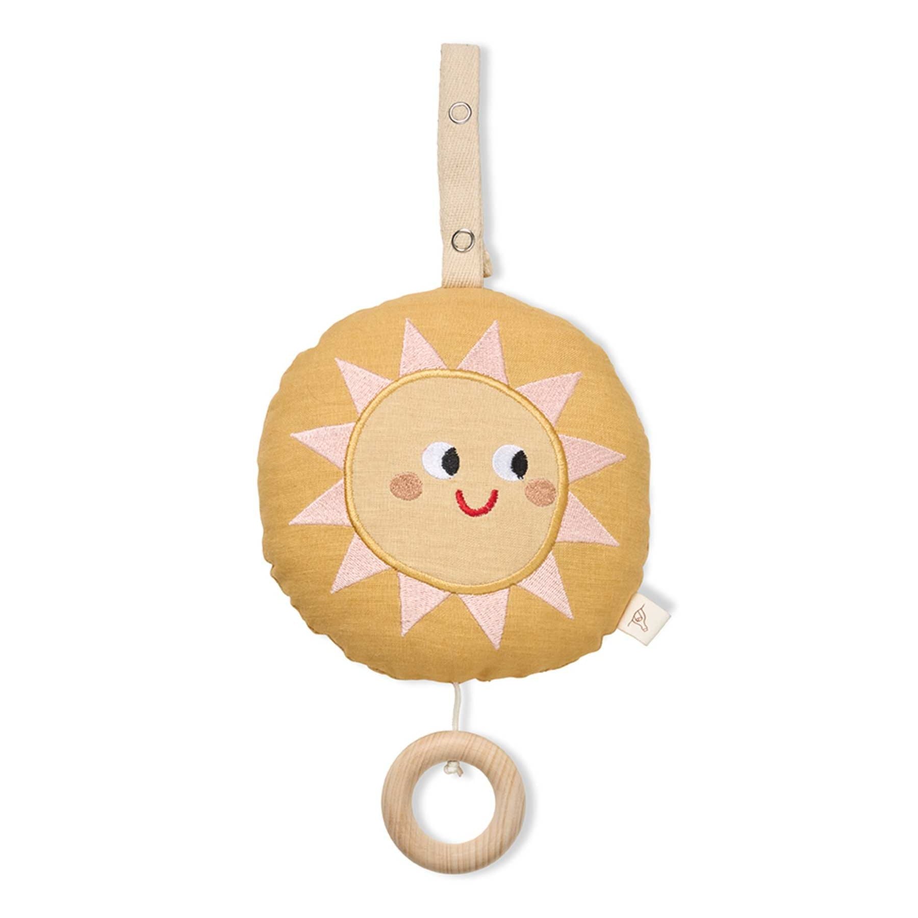 A baby sensory toy featuring a round, plush sun design in a warm mustard yellow fabric with embroidered pink and white rays, a smiling face, and a natural wooden ring handle hanging below