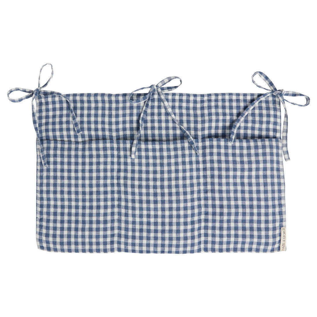 Hazel &amp; George Linen Bed Pocket in Vichy, a linen storage pocket in blue-and-white check with three ribbon ties and three compartments, on a white background