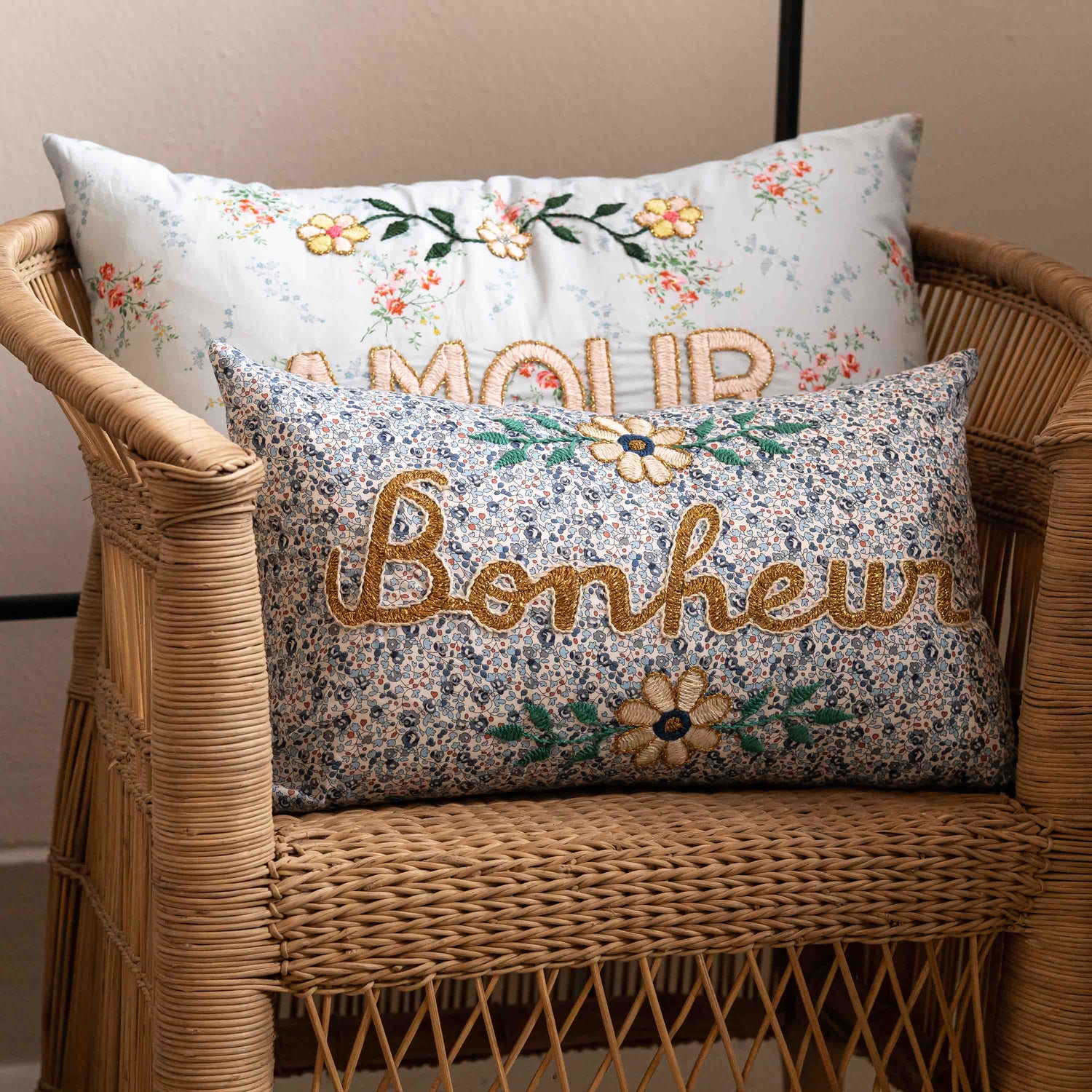 Decorative pillows with floral patterns and embroidered text