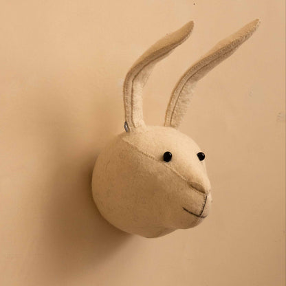 A cream-colored felt rabbit head wall mount with long upright ears