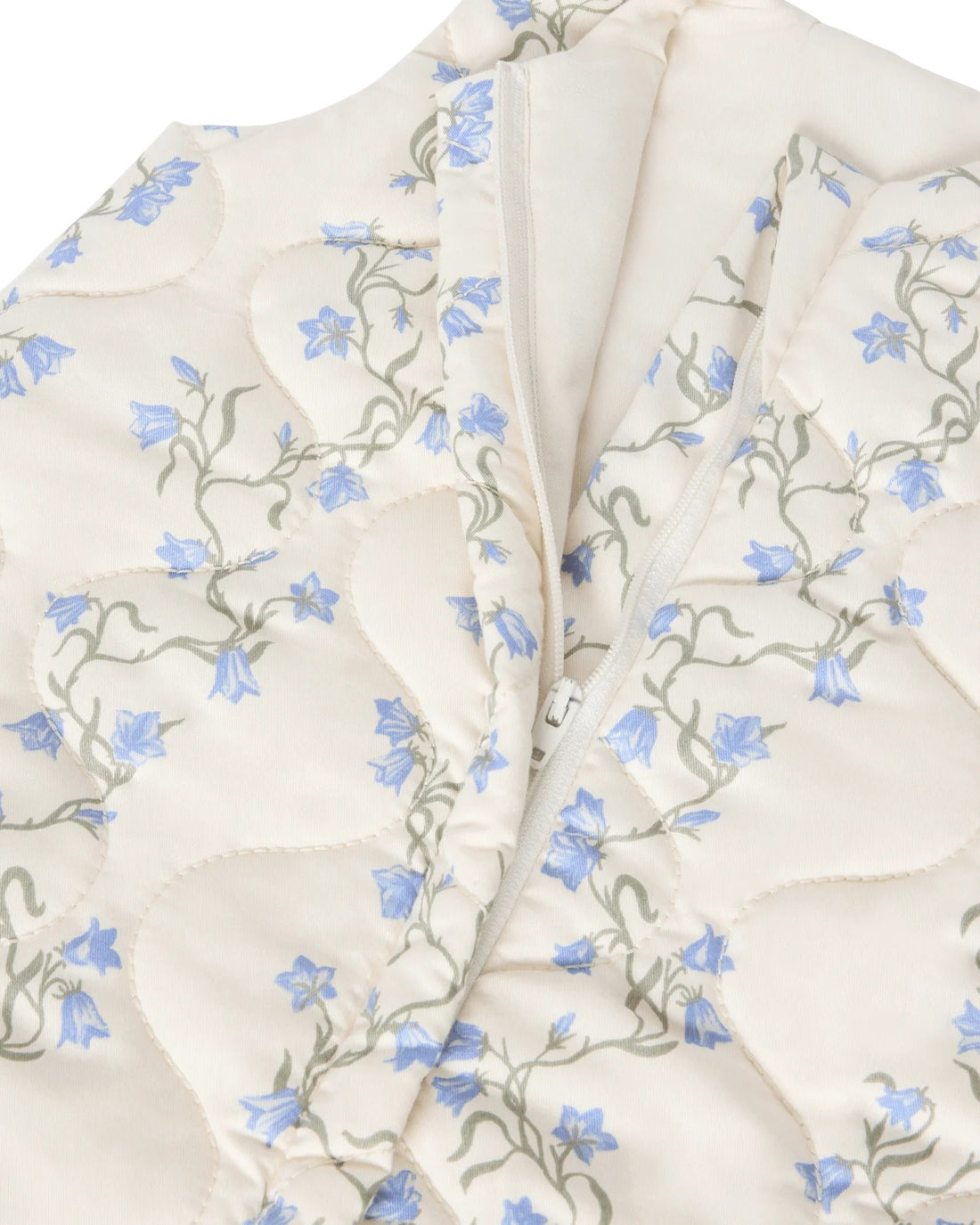 Floral patterned fabric with blue flowers and green leaves on a white background
