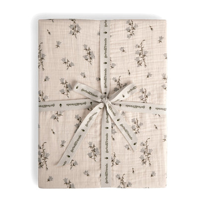 A folded fitted sheet with a floral pattern, tied with a ribbon.