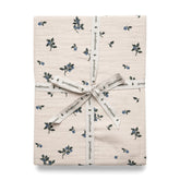 Folded fitted sheet with blueberry pattern, wrapped with ribbon and tag displaying the brand name.