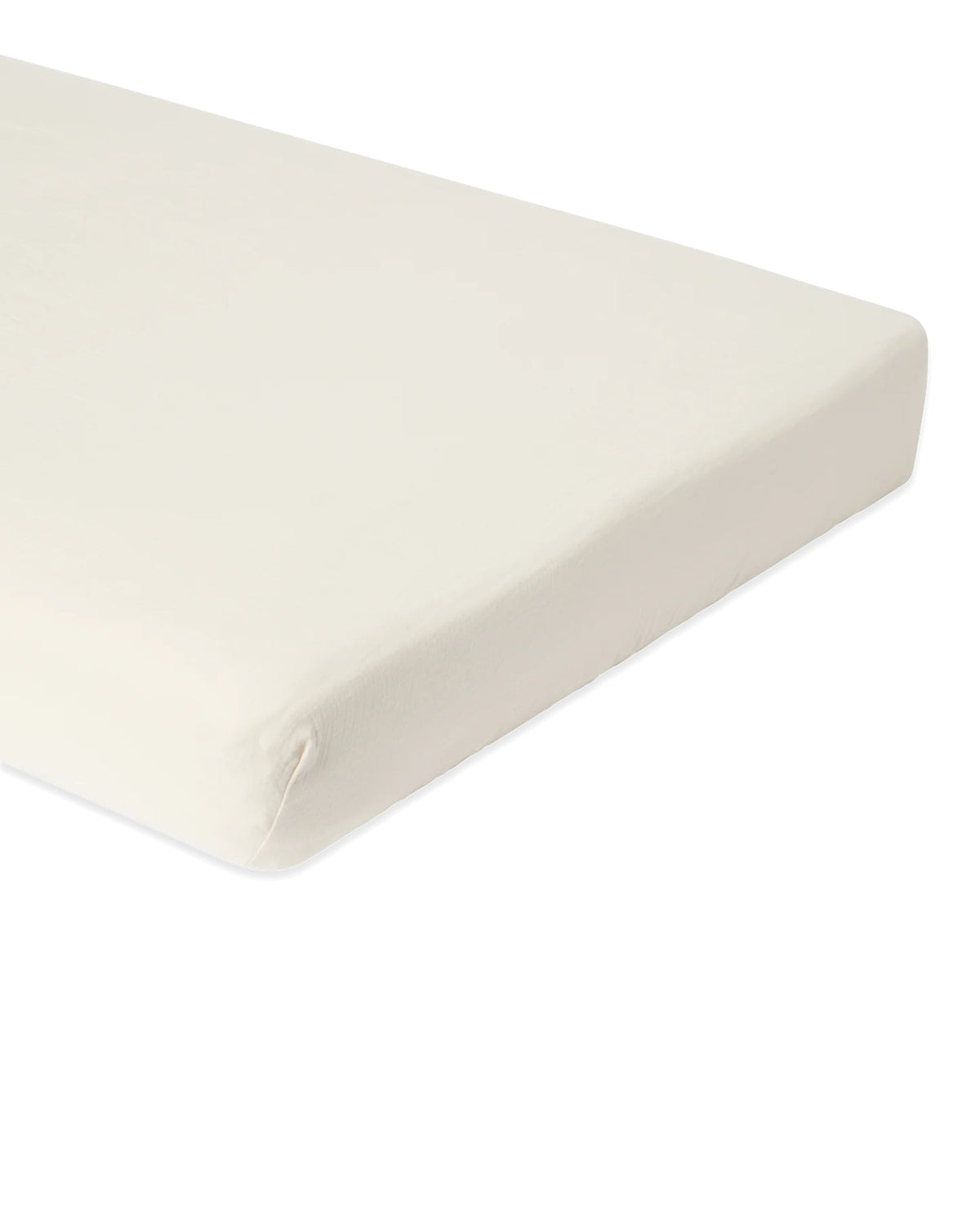 A close-up of a white fitted sheet covering a mattress corner, shown against a plain white background.