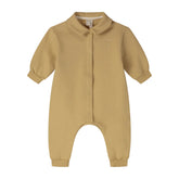 A baby long-sleeve romper in a warm mustard yellow color, featuring a button-up front, a small embroidered logo on the left chest, and a pointed collar.