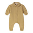A baby long-sleeve romper in a warm mustard yellow color, featuring a button-up front, a small embroidered logo on the left chest, and a pointed collar.