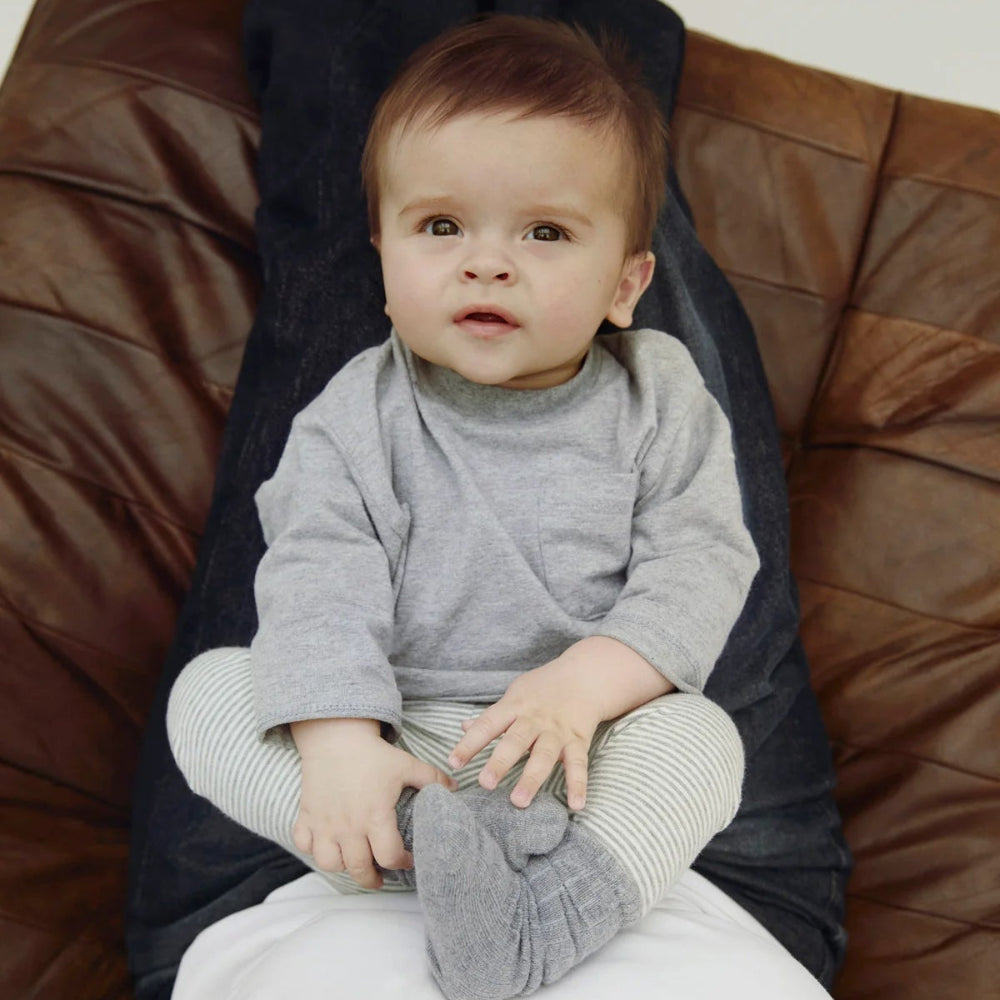 Baby in a gray outfit sitting 