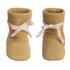 A pair of mustard yellow knit booties with white ribbon bows tied around the ankles