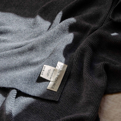 Close-up of the Hazel &amp; George label and care instructions on a Merino Blanket in Charcoal