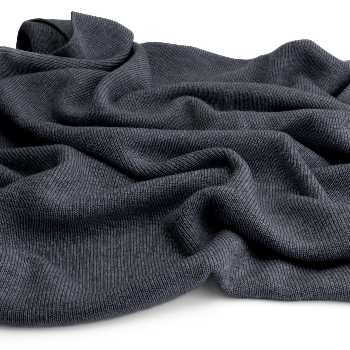 Close-up of the knitted merino wool fabric of the Hazel &amp; George Hazel Merino Baby Blanket in Charcoal, draped on a white background