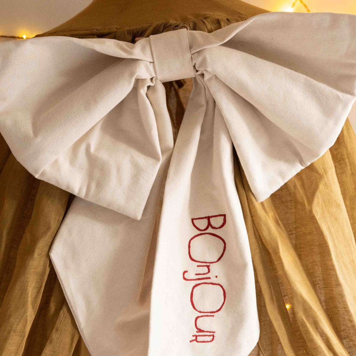 Detail of the Hazel &amp; George Personalized Festive Bow Large in cream, showing the &