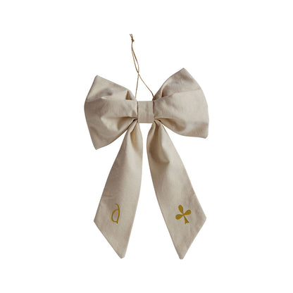 Hazel &amp; George Canvas Festive Bow Small in cream, embroidered with a green clover and initial on the tails, on a white background