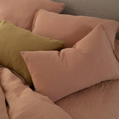 Bed styled with Hazel &amp; George linen pillows in Cinnamon and one Mosswood pillow