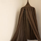 Brown curtain hanging against a beige wall