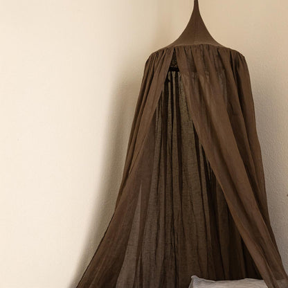 Brown curtain hanging against a beige wall