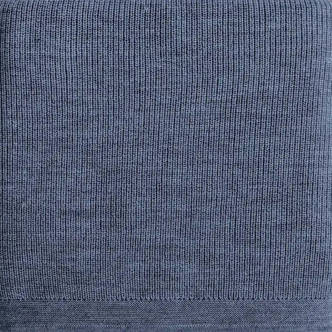 A denim blue ribbed knit fabric detail of a merino blanket