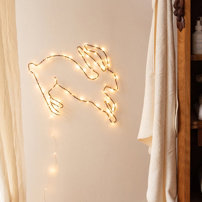 Handgemaakte zwarte wandlamp in de vorm van een haas, met koperkleurige LED-verlichting, Zoé Rumeau — sfeervol nachtlampje voor de kinderkamer.