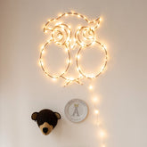 Handgemaakte zwarte wandlamp in de vorm van een uil, met koperkleurige LED-verlichting, Zoé Rumeau — sfeervol nachtlampje voor de kinderkamer.