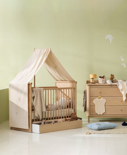 Camp Novel undyed embroidered cot canopy shown in a nursery