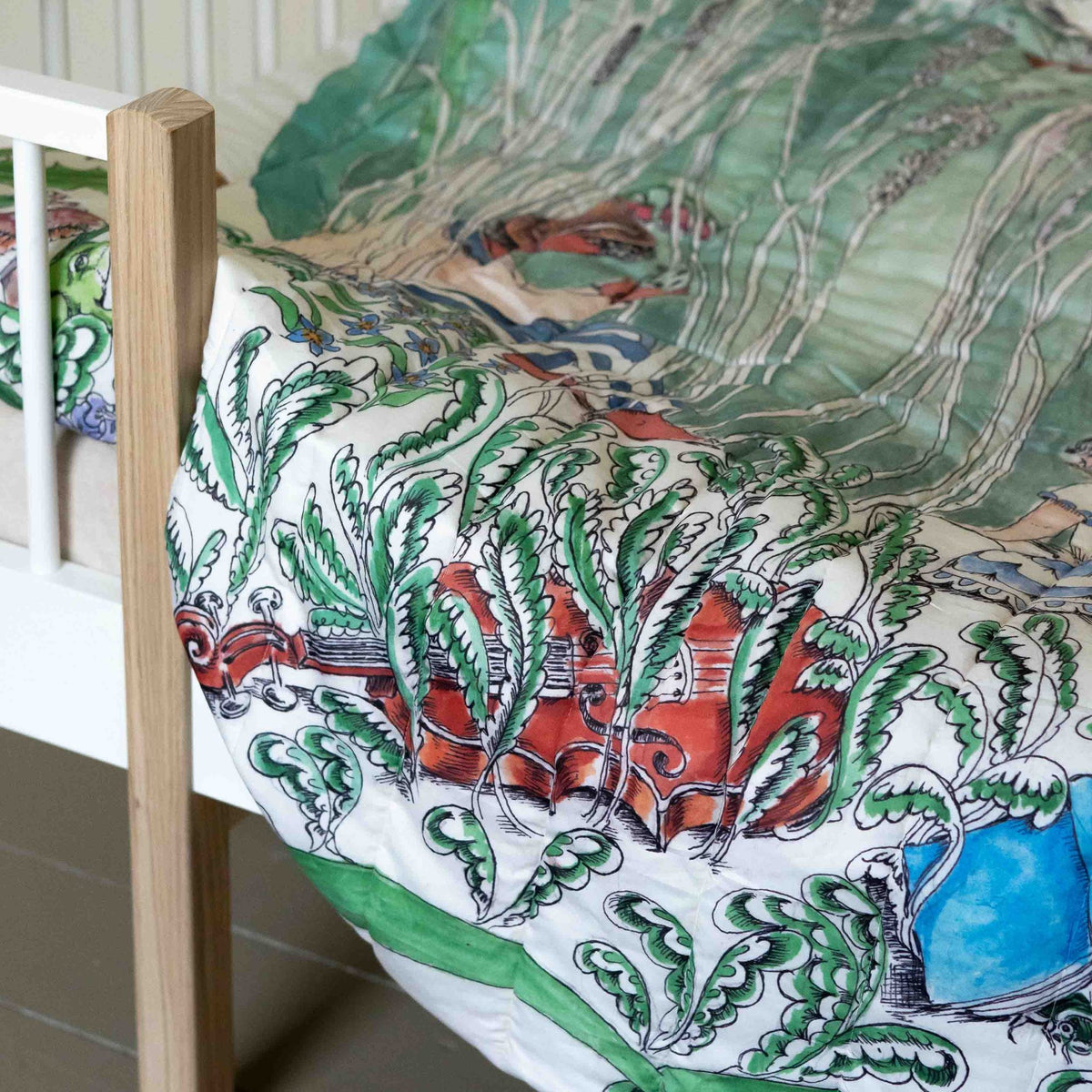 A reversible quilted blanket illustrated with a pond scenery, day on one side and night on the other.