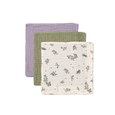 Three fabric swaddles in purple, green, and white with floral pattern