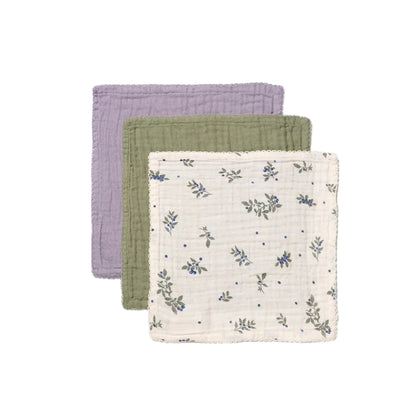 Three fabric swaddles in purple, green, and white with floral pattern