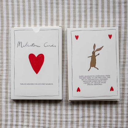 Two Milestone Cards boxes lying on striped linen fabric