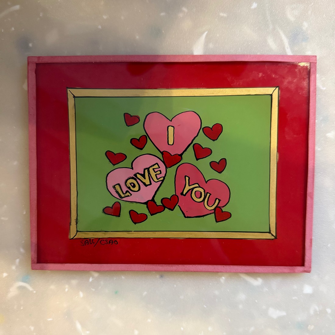 A square framed art print featuring three pink hearts with the words &
