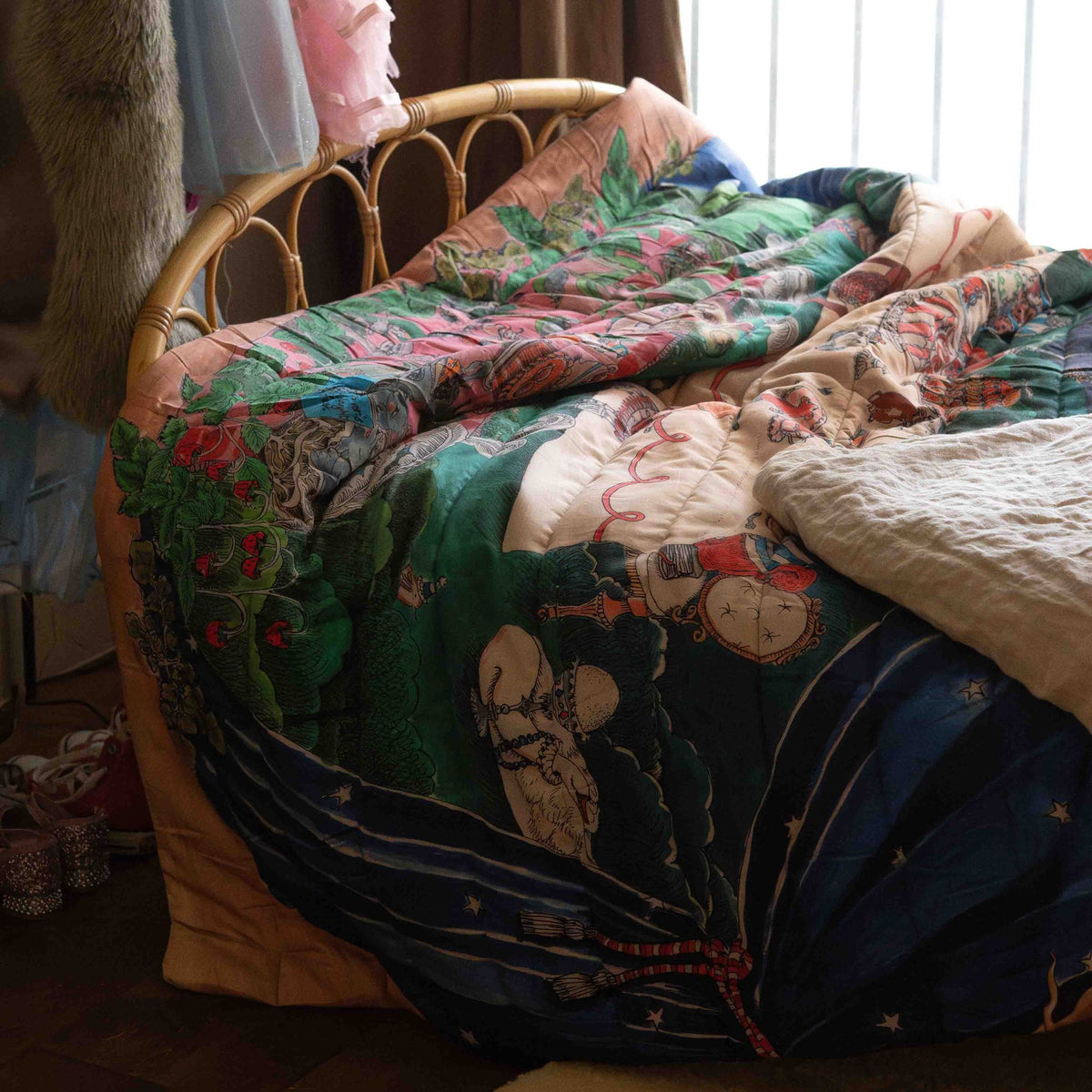 A reversible quilted blanket illustrated with woodland animals gathered around a festive table on one side and a plate motif on the other.