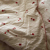 Close-up of the Garbo&Friends Filled Blanket in Seersucker Poppy, showing the quilted seersucker fabric