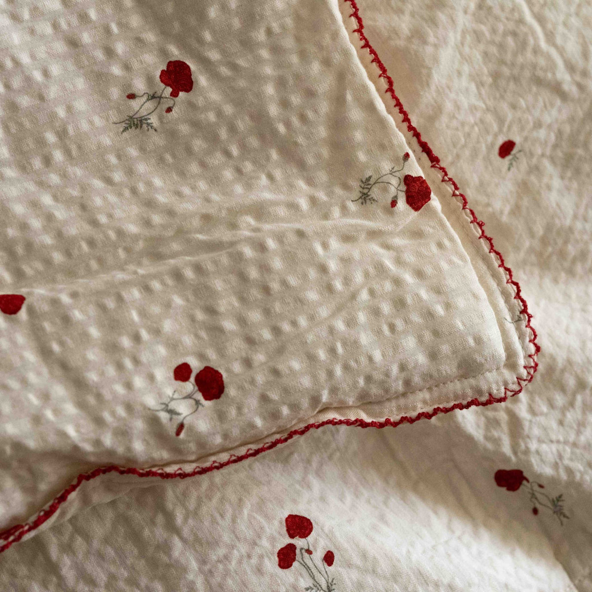 Close-up of the Seersucker Poppy fabric on the Garbo&amp;Friends Filled Blanket