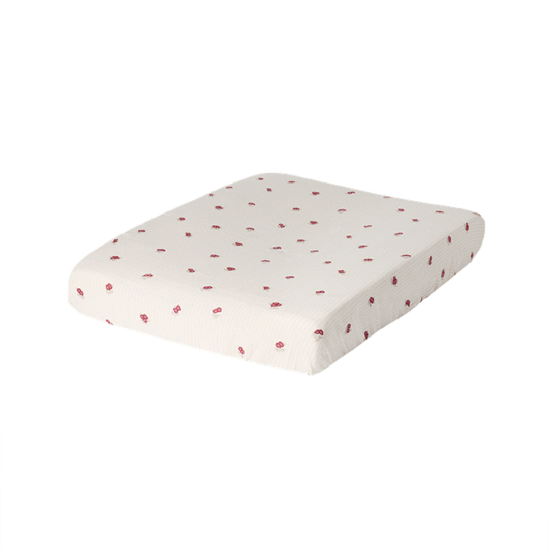Garbo &amp; Friends Muslin Changing Mat Cover Rosehip on a changing pad, ivory organic cotton muslin with small rosehip-red flowers