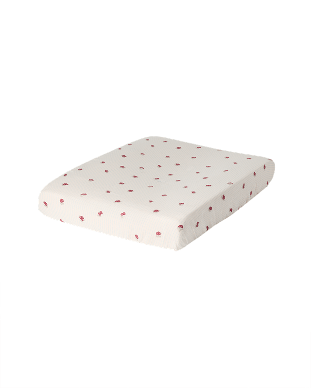 Garbo &amp; Friends Muslin Changing Mat Cover Rosehip on a changing pad, ivory organic cotton muslin with small rosehip-red flowers