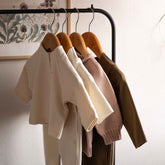 Gray Label Baby Cardigan in Cream, styled on a clothing rail alongside other Gray Label pieces