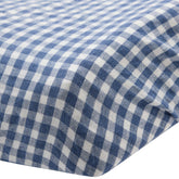 Close-up of the corner of the Hazel & George Linen Changing Mat Cover in Vichy, showing the blue-and-white check fabric and fitted edge