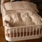 Hazel & George Linen Duvet Cover in Craie on a toddler bed with a bed rail, with a matching pillow