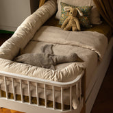 Hazel & George Linen Duvet Cover in Naturel on a toddler bed with a bed rail, styled with stuffed animals