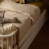 Hazel & George Linen Duvet Cover in Naturel on a toddler bed with a bed rail, with a stuffed goose toy