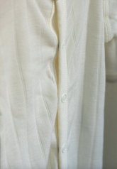 Close-up of a white shirt with buttons on a light background