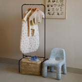 Hazel & George Metal Clothes Stand in a nursery, hung with baby clothing above a woven basket, next to a child&