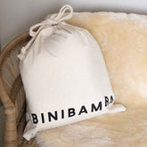 Binibamba sheepskin snuggler in Milk shown with its cotton dust bag